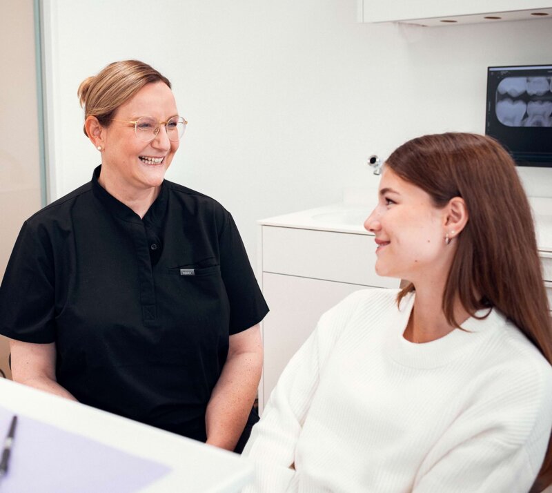 Frau Schönleber unterhält sich im Behandlungszimmer mit einer jugendlichen Patientin.