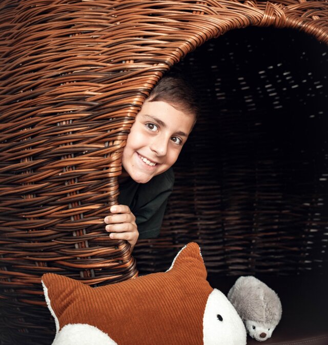 Ein Junge versteckt sich im Kobel.